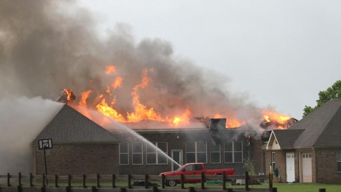 Firefighters battle flames that destroyed a house Sunday in Powersville in Peach County.