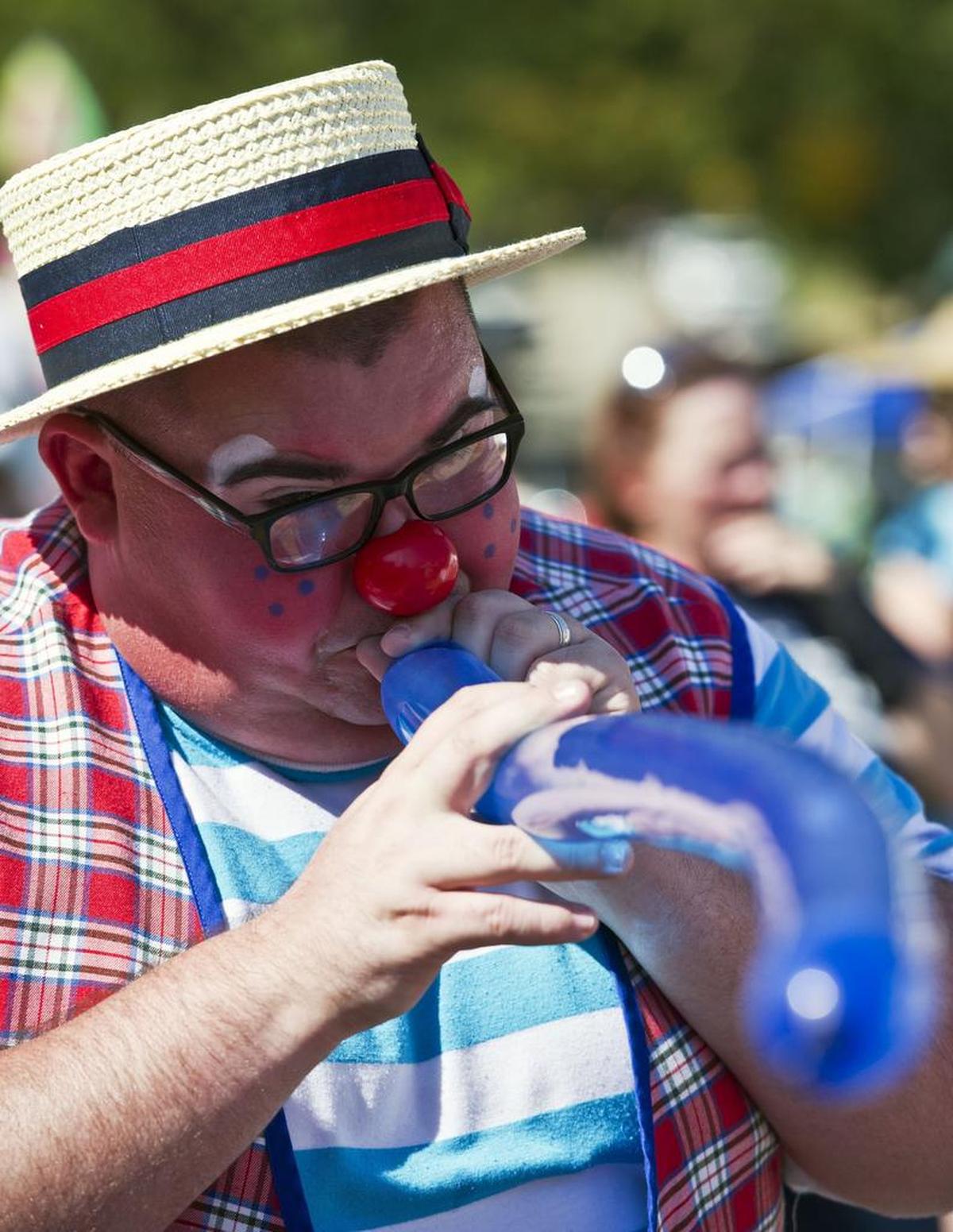 Lee Andrews, “Lew-e the Clown”, makes a balloon animal at the 2016 Green Tomato Festival in Juliette Saturday, Oct. 29, 2016.