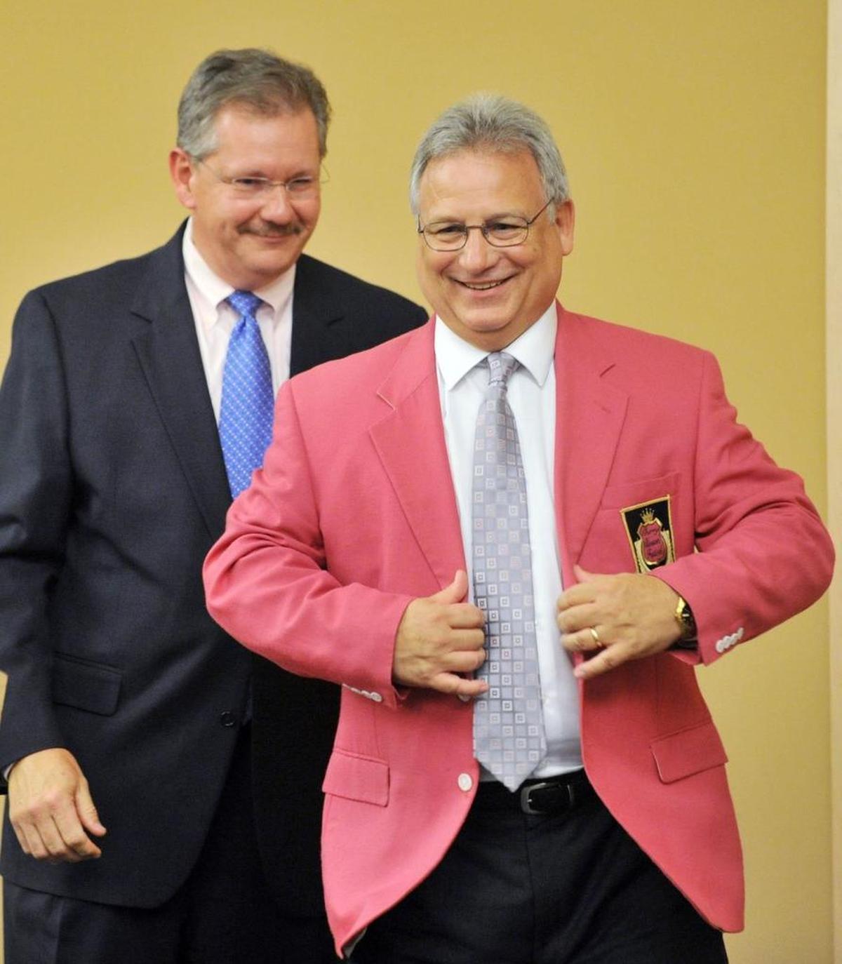 Cherry Blossom Chairman George McCanless, left, presents a pink sport coat to Richard Brewer during a ceremony June 14, 2012, naming him the new Cherry Blossom Festival CEO.