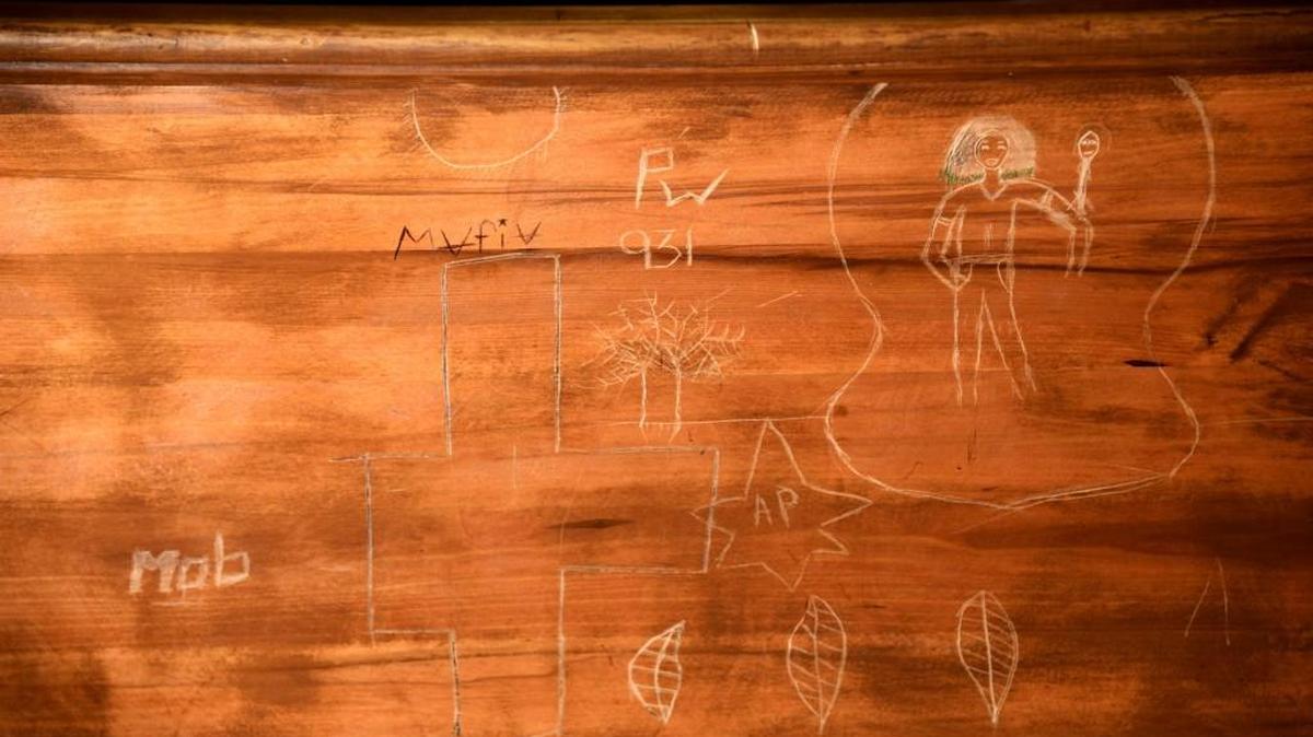 Graffiti carved into the benches at the Bibb County courthouse.