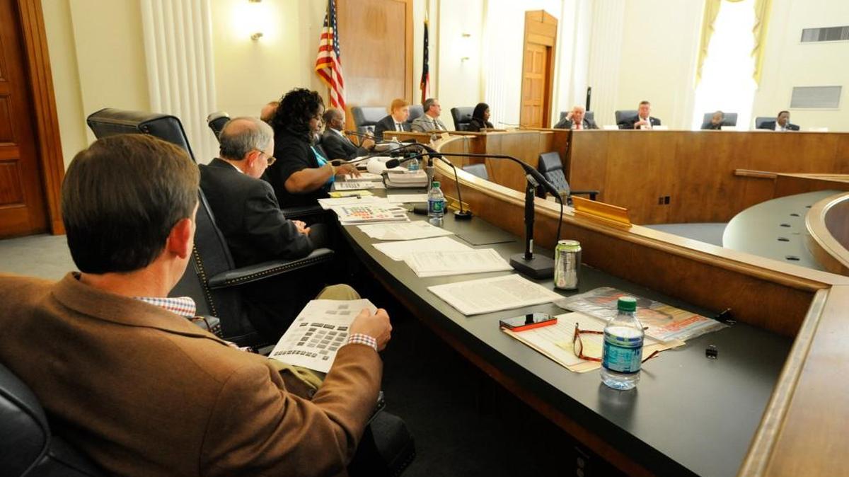 Macon-Bibb County Commissioner Gary Bechtel holds an organizational chart for the consolidated government during discussion at a commission meeting in April 2014.