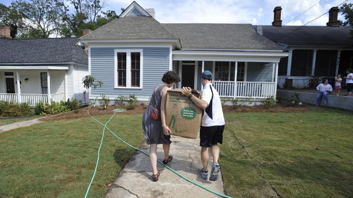 Elizabeth and Matt Harper a move a box into their new home on Calhoun Street in the Beall's Hill neighborhood in 2014. The couple teach at Mercer University and have two children Lillian, 8, and Charity, 4.