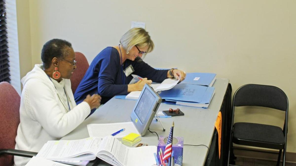 Warner Robins city poll workers Sharon Mosley, left, and Robin Way wait for voters to come in during early voting at City Hall on Tuesday.