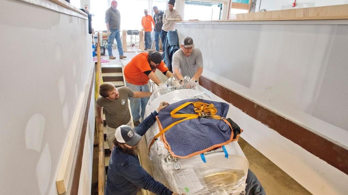 A brite tank is lowered down a stairwell at Piedmont Brewery & Kitchen in November. The restaurant and pub will hold its grand opening March 27.