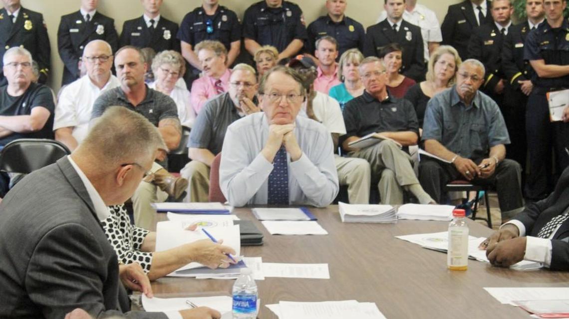 Sherman Yehl of Valdosta State University discusses findings of a pay scale study of the city of Warner Robins with council members Monday as firefighters and others look on.