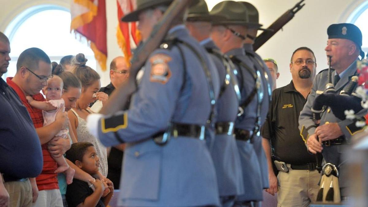 Family members and friends of slain Eastman Police Officer Tim ``Turtle'' Smith watch a color guard present colors during a prayer service for the policeman who was gunned down Saturday night while on duty.