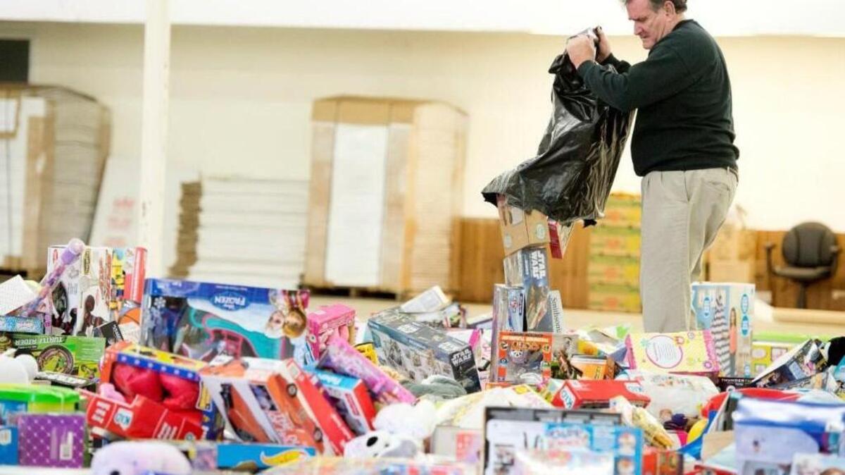 Founder Joe Allen empties one of forty-five large bags of toys donated by Tattnall Square Academy at the Kids Yule Love warehouse in Byron in December of 2015.