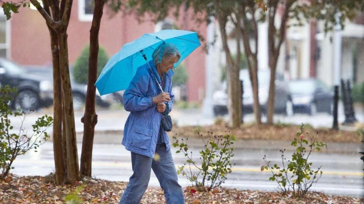 Barbara Miles walks along Second Street in the rain on Tuesday. “I love it,” she said of the rain.