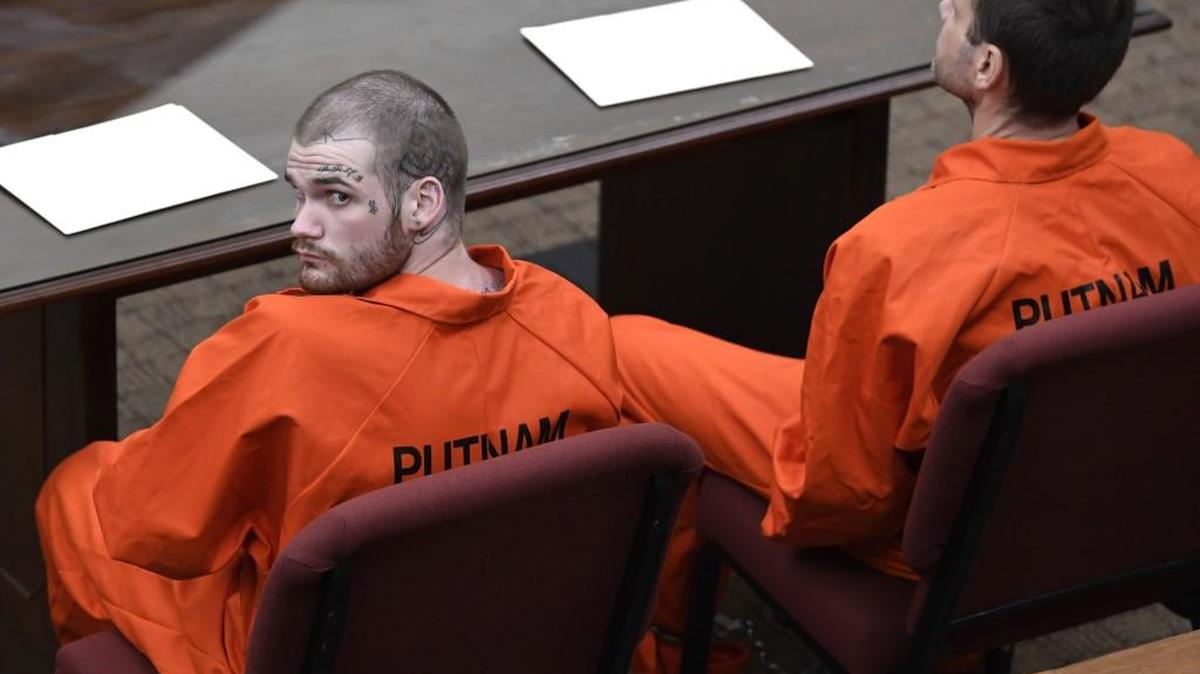 Ricky Dubose looks up to the courtroom balcony at news cameras covering his and Donnie Rowe's first appearance in court in Putnam County last month.