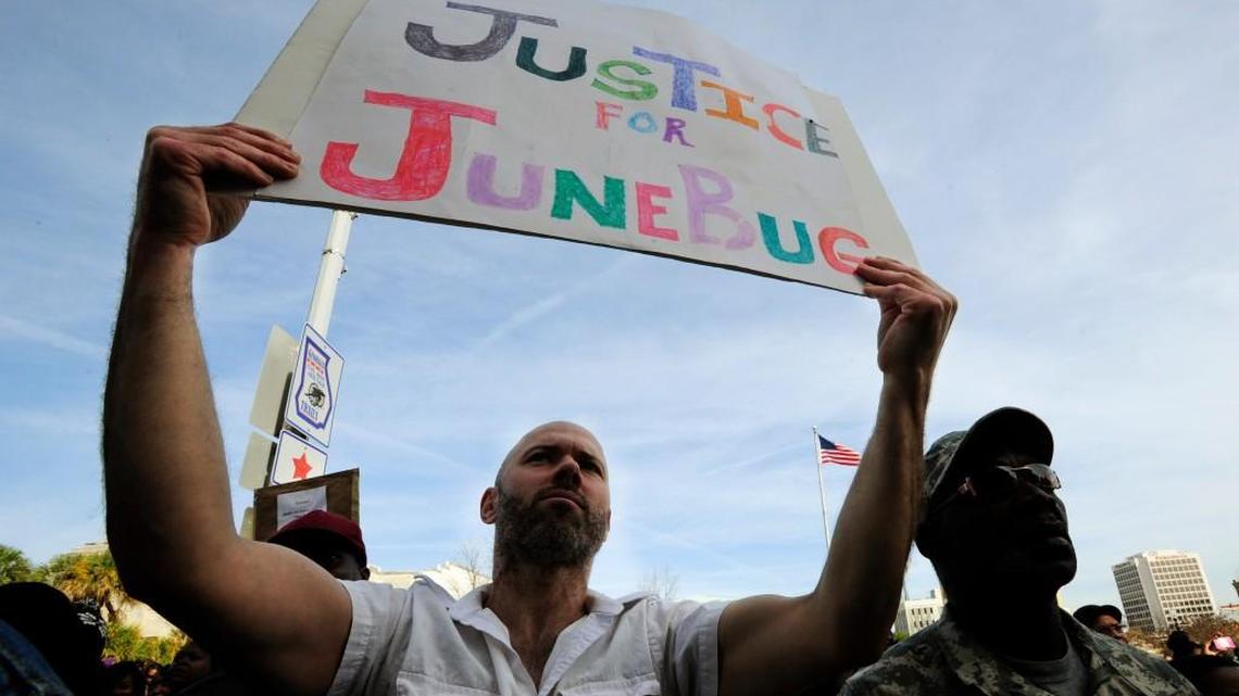 Anthony Harris holds a sign at Macon City Hall during the Martin Luther King Jr. Day memorial march in 2013. Sammie “Junebug” Davis Jr. was shot and killed by a Macon police officer.