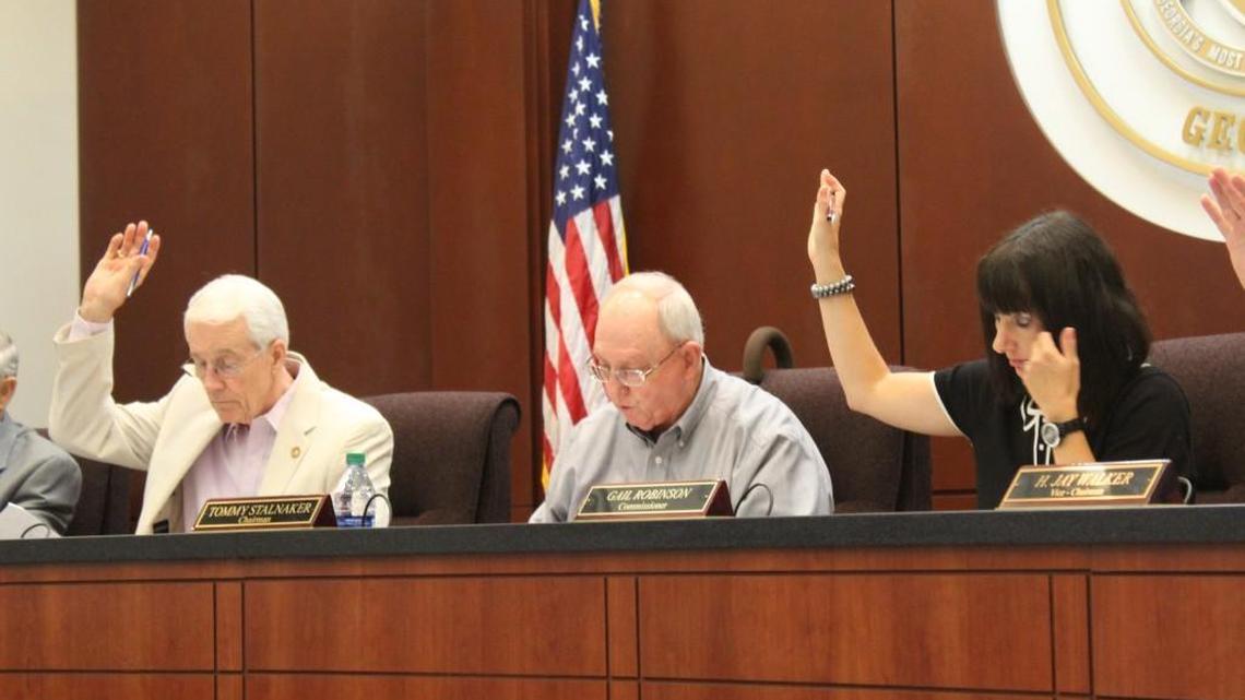 Houston County Commission Chairman Tommy Stalnaker, center, calls for the vote Monday on setting the property tax rate. Commissioners Larry Thomson and Gail Robinson raise their hands in favor.