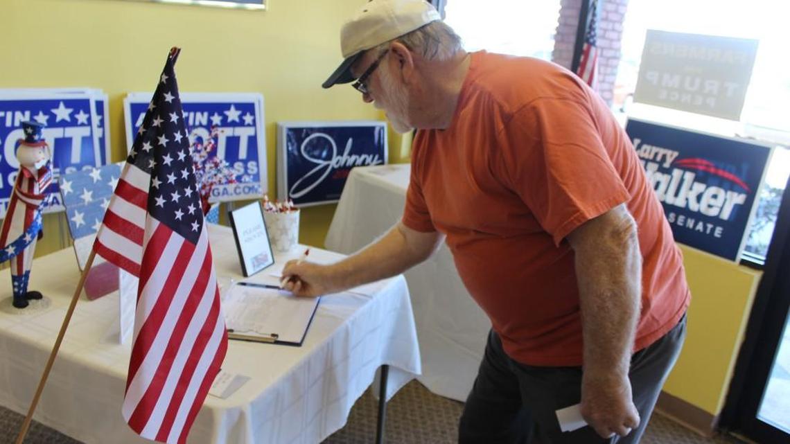 Ray Hubbard of Warner Robins signs up for the mailing list of the Houston County Republican Party at its headquarters Monday after he bought some buttons supporting Donald Trump for president.
