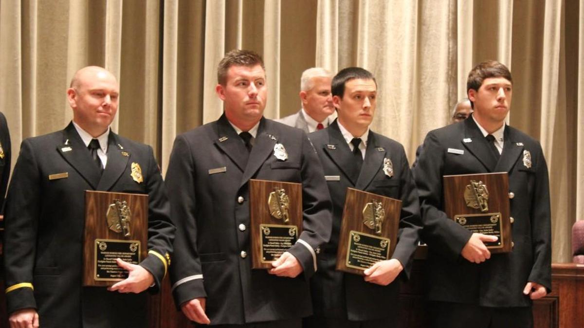 From left, Warner Robins firefighters Russell Oakley, Justin Sadler, Shelby Wilkes and Patrick Mobley hold the Lifesaving Valor Award they received for their actions on Aug. 28 in pulling a woman from a burning house.