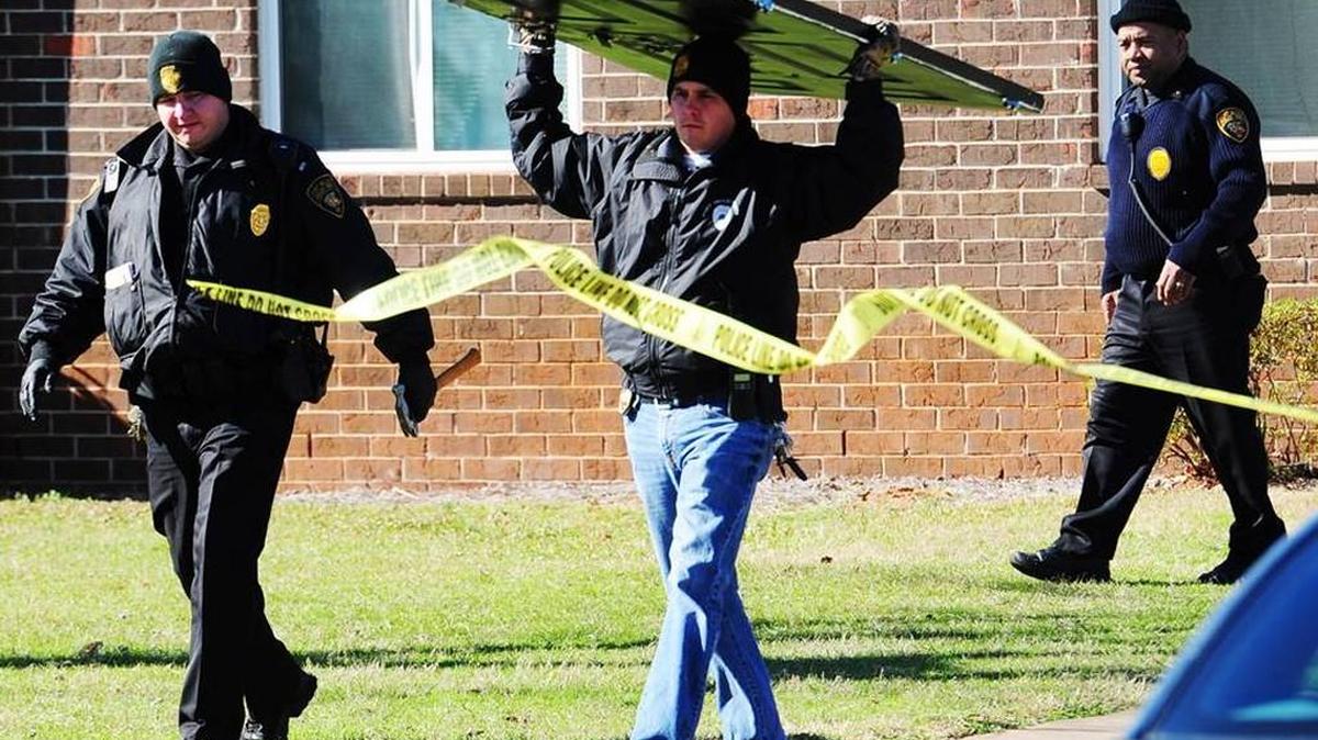 Police carry the front door to a Georgia Bureau of Investigation’s vehicle. Eight-year-old Jai’Mel Anderson was fatally wounded when bullets flew through the door, striking him once in the leg and once in the upper torso as he lay on an air mattress in the living room of a Fort Valley apartment just before 1:40 a.m. Jan. 6, 2015.