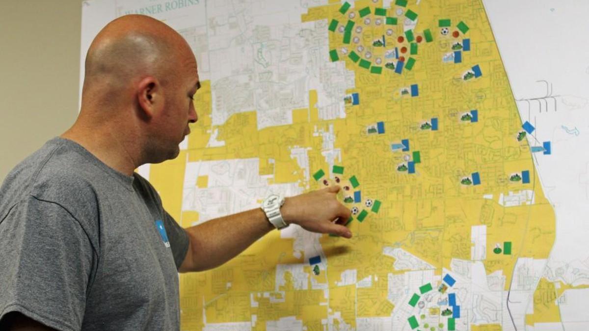 Warner Robins Recreation Director Jarred Reneau shows a map where he has placed emblems for all city parks and emblems showing how those parks might be improved.