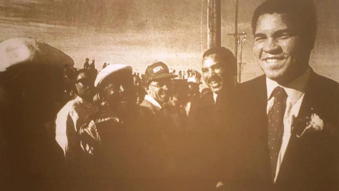 Muhammad Ali jokes with a crowd gathered around him at the Fort Valley State-Savannah State game in 1989.