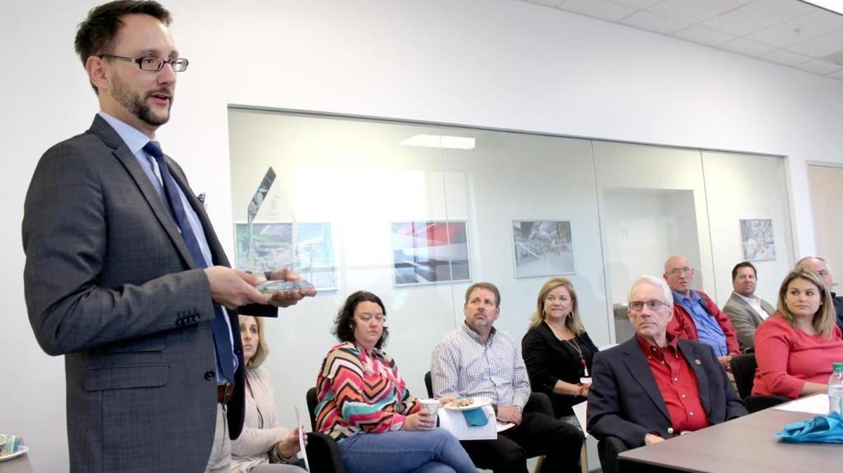 Tobias Baumgaertel, president of Sandler Nonwoven in Perry, speaks to the Houston County Development Authority at the plant Wednesday. He is holding the “Deal of the Year” award the received from Georgia Economic Developers Association for the effort to locate the plant in Perry.