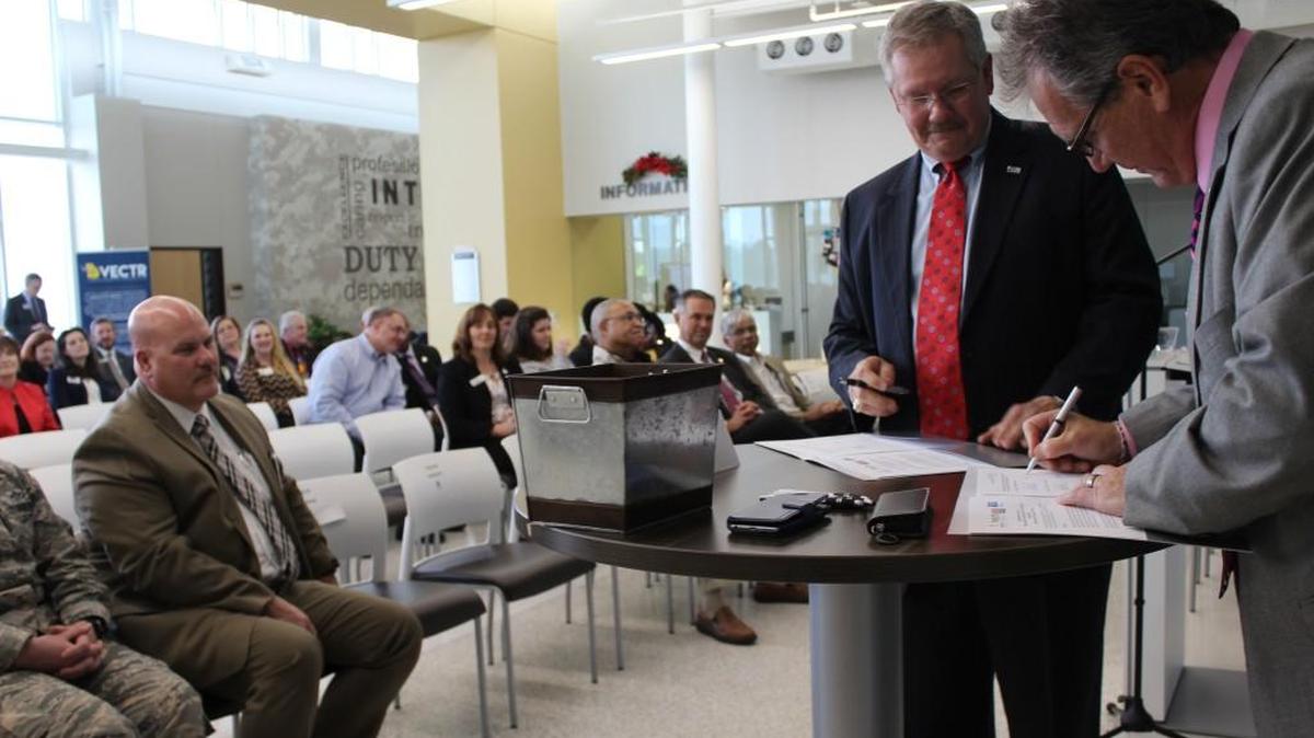 George McCanless, president of United Way of Central Georgia, left, and Middle George State University President Christopher Blake sign an agreement for the United Way to help veterans at the new veterans training center in Warner Robins.