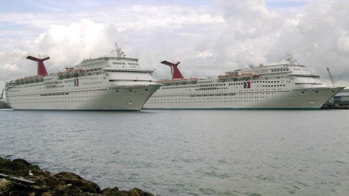 Carnival Cruise Line’s Ecstacy, front, sails past the Paradise, at the Port of Miami in this 2000 file photo.