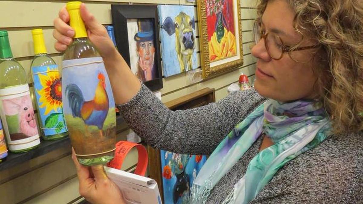 Jodi Daley looks at a piece of art donated by Diane McClarnon titled “Red Rooster.”