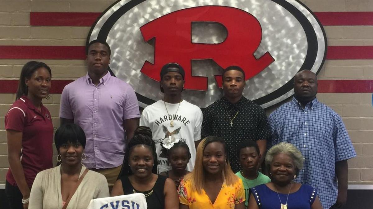 Aniya Clay, front row, second from the right, is joined by her family and Warner Robins High School track Coach Rebecca White as Clay signed her scholarship papers for Fort Valley State University.