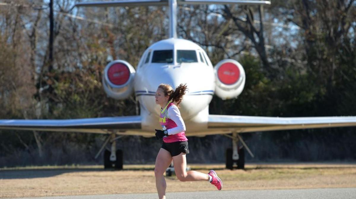 Patricia Coppel, of Atlanta, runs the home stretch of the Museum of Aviation’s half-marathon in 2014.