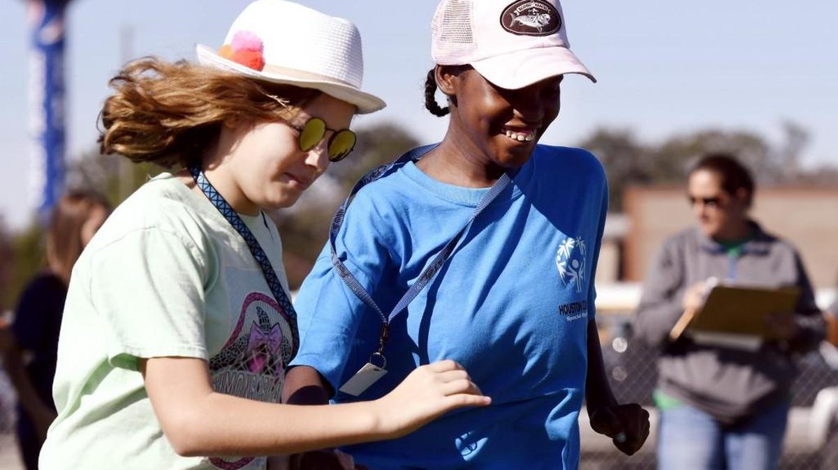 Partner Stella McBride, left, helps Kamaya Dickson run the bases during a softball skills completion at the Houston County Special Olympics Friday.