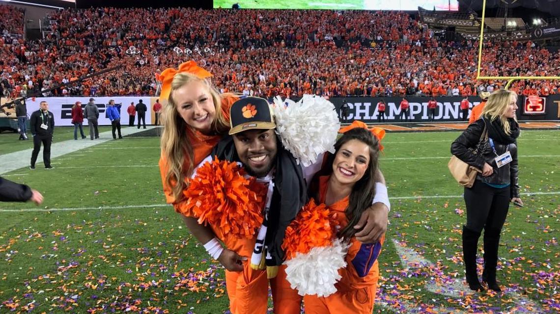 Clemson University cheerleaders Halie Manion, right, and Olivia Cecil celebrate the school’s college football national championship win with player DJ Greenlee after the victory against Alabama on Jan. 9 in Tampa, Florida.