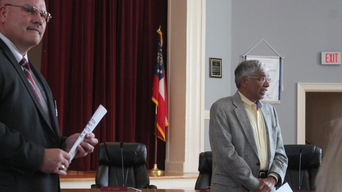 Manoj Shah, right, talks about his donation to gifted teachers as Mark Scott, superintendent of schools in Houston County, looks on.