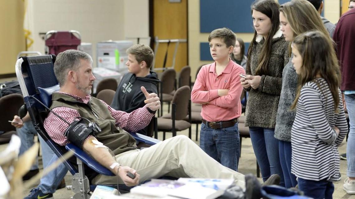 Surrounded by his four children, Jonathan Knight gives blood Friday at Westfield Schools. The drive was set up by the Key Club and while some first-time givers brought their own support teams, Knight said the gang watching him “is more fascination than support.’’ Organizing blood drives are one of the important functions of the American Red Cross.
