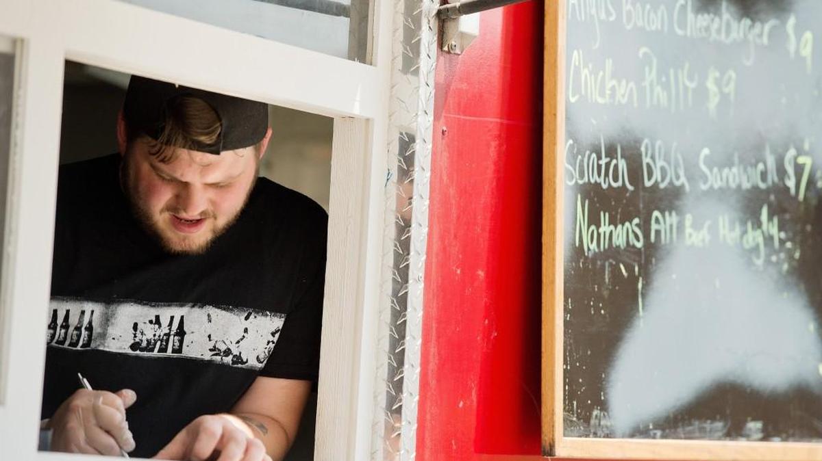 James Kilelee writes down an order at the Scratch Cuisine food truck at the Museum of Aviation.