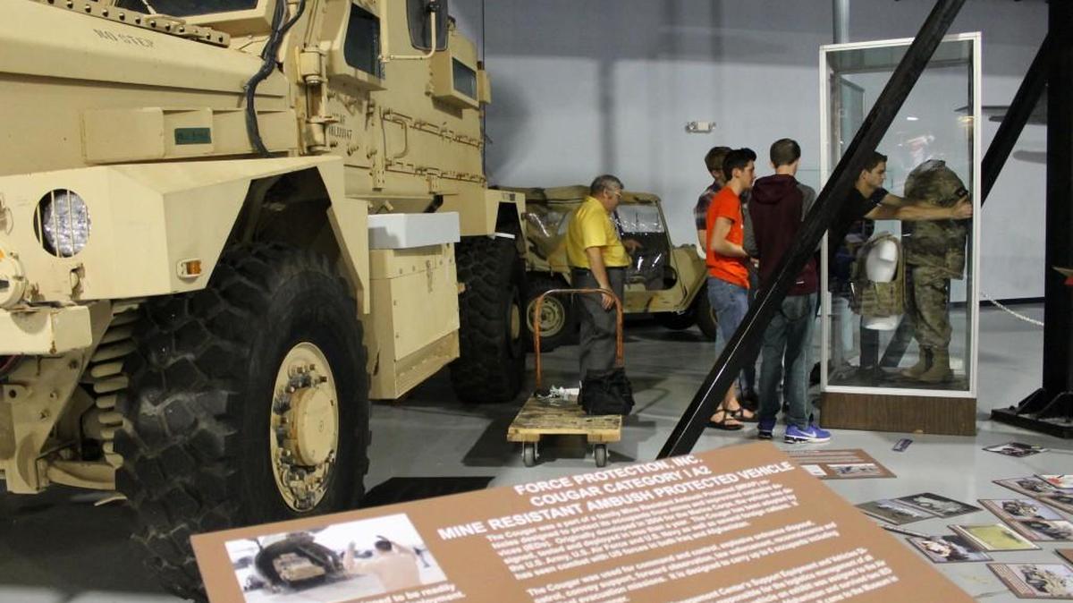 Northside High School seniors Korey Cutlip, Alex Doyle, Tim Campbell and Jordan Pierce work at the Cougar Mine-Resistant Ambush Protected vehicle exhibit they helped put together at the Museum of Aviation.