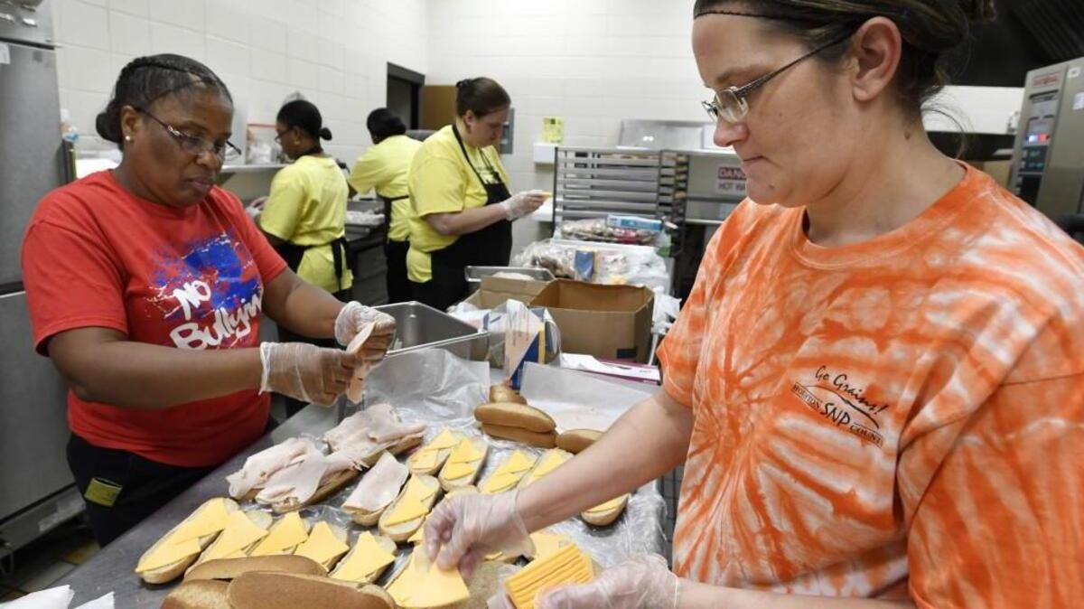 Doris Wynds, left, and Wendy Collins make sandwiches in the Huntington Middle School kitchen.