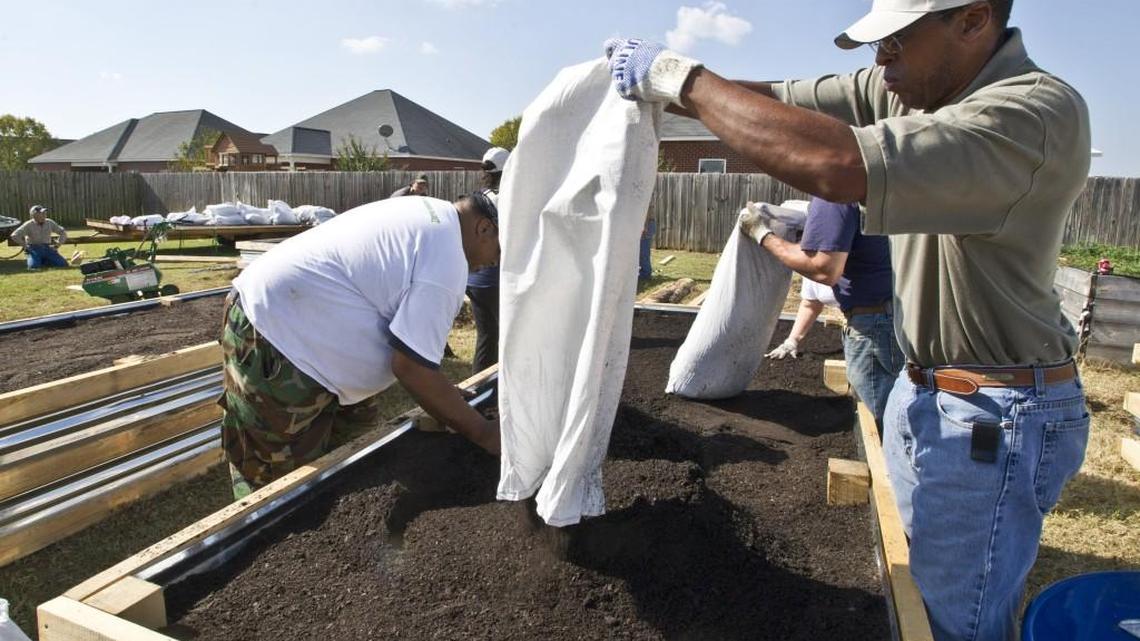 Billy Brown dumps a bag of organic soil into a raised garden bed on Friday, Nov. 4, 2016. Brown was volunteering with Farm Again/AgrAbility Project to to make the beds for disabled veteran Tim Anderson. Farm Again/AgrAbility Project is a Georgia program that helps farmers with disabilities get back to farming again.