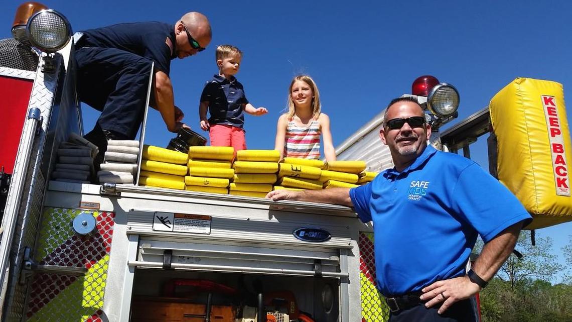 Centerville firefighter Dustin Talley gives 2-year-old Jace Dorman and Eagle Springs Elementary School fourth-grader McKayla Kahley the view from atop a fire engine at Center Park at Centerville as Fire Chief Jason Jones stands at the end of the vehicle.