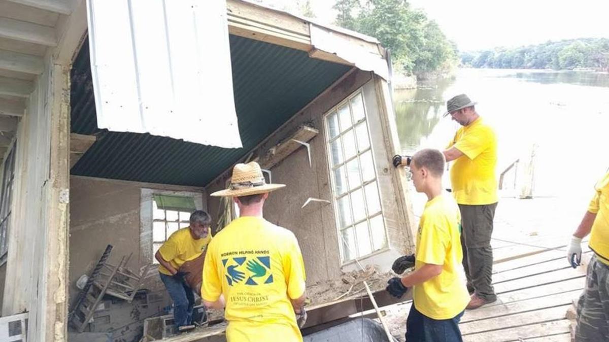 Members of Warner Robins First Ward of the Church of Jesus Christ of Latter-Day Saints work on cleaning out a home that had been partially submerged by a river.