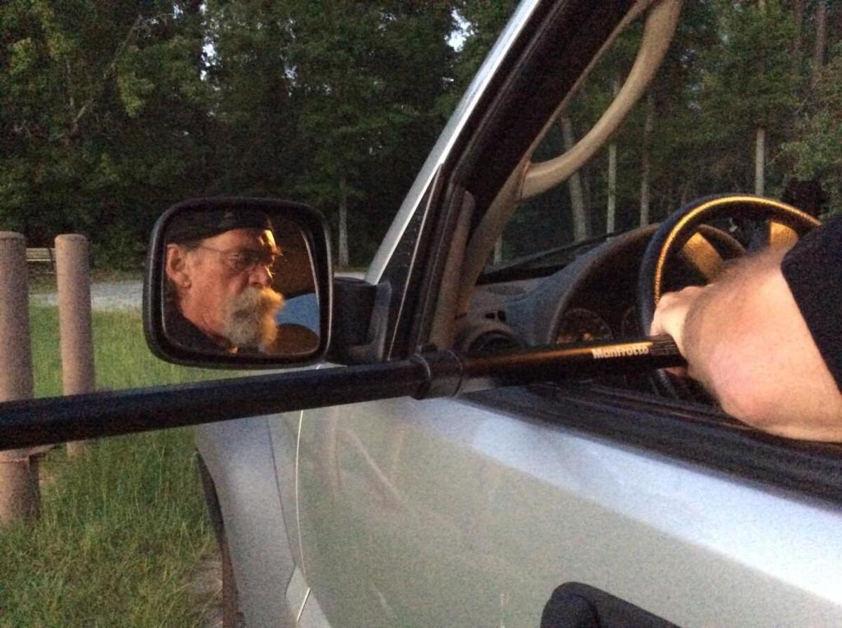 Robins Air Force Base photographer Claude Lazzara looks over Thursday morning’s sunrise picture in the driver’s seat of his Jeep.