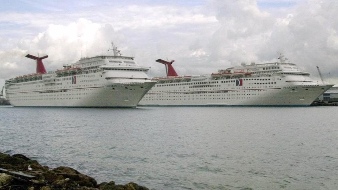 Carnival Cruise Line’s Ecstacy, front, sails past the Paradise, at the Port of Miami in this 2000 file photo.