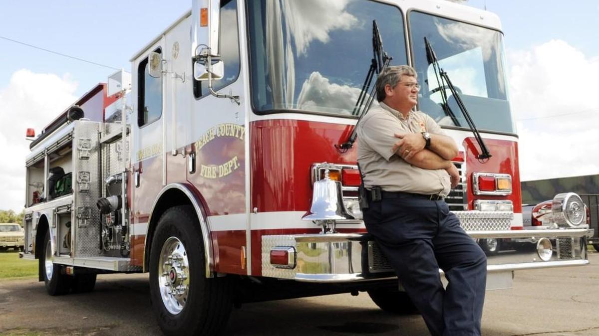 Peach County Fire Chief and EMA director Jeff Doles with one of two identical pumper trucks in this Telegraph file photo.