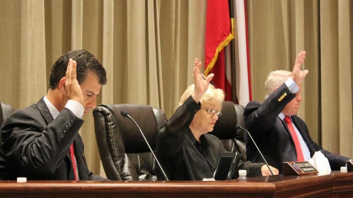 From left, Warner Robins council members Chuck Shaheen, Carolyn Robbins and Keith Lauritsen vote in favor of a list of purchasing bids that include funding for a Vietnam memorial wall.