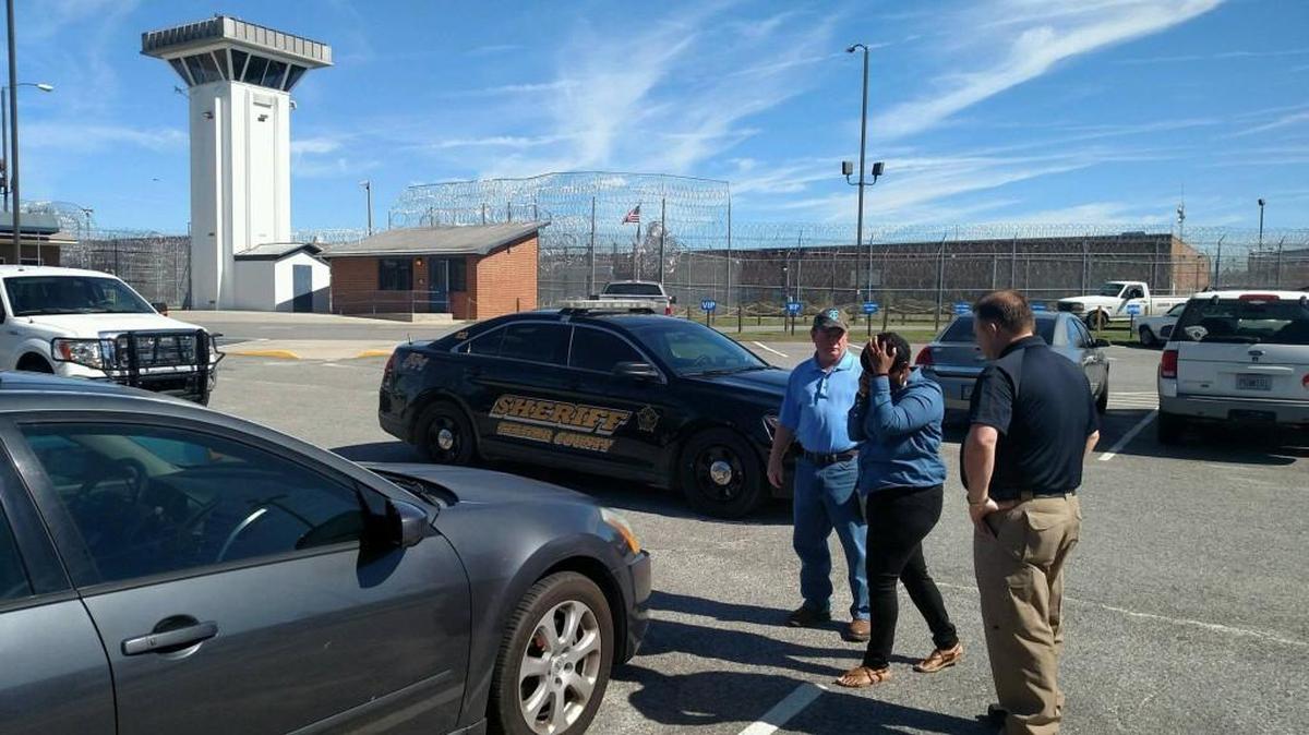 Telfair State Prison Warden Phil Hall, left, and Telfair County Sheriff Chris Steverson flank a woman suspected of using children to smuggle drugs into Telfair State Prison on Monday, Oct. 10, 2016.