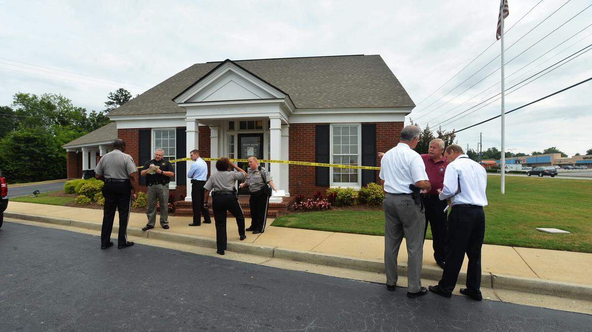 Bibb County Sheriff's deputies compare notes after a man robbed the State Bank branch on Pio Nono in south Macon Thursday morning.
