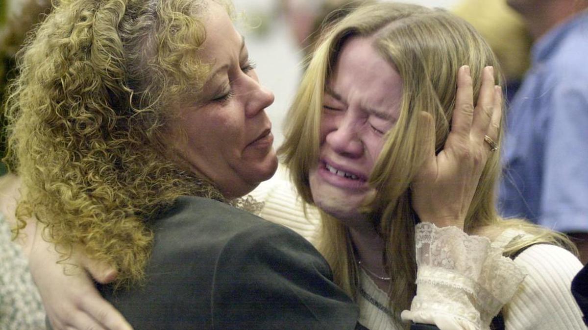 Gerri Moss, whose husband and children were shot dead in 1998, comforts Lacy Lucas in court in the late 1990s. Lucas' brother, Daniel Lucas, is scheduled to die by lethal injection Wednesday.