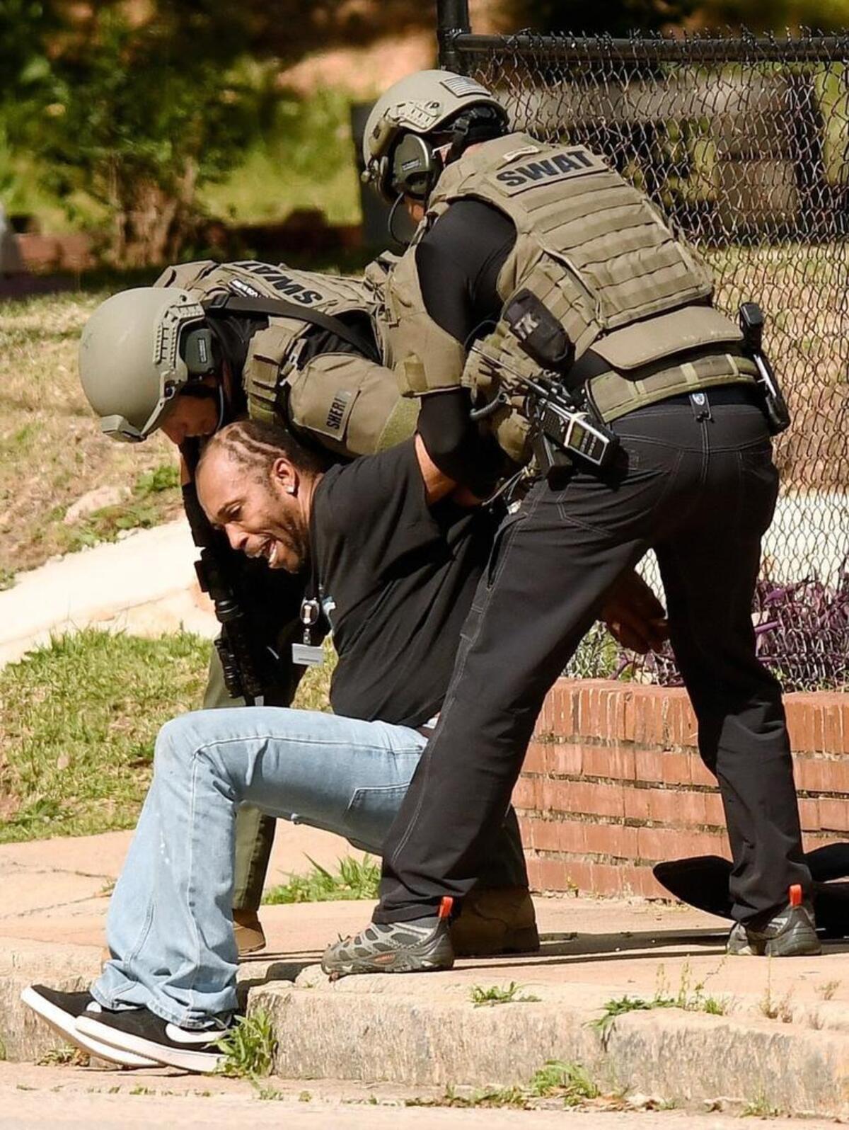 Members of the Bibb County Sheriff’s Office SWAT team sit Reginald Wilmore on the curb on Ross Street after he was put into custody in April of 2017 after a standoff put local schools on lockdown.