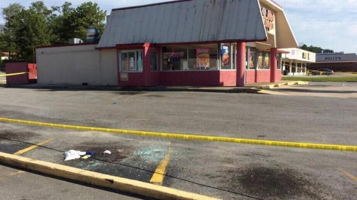 Broken glass shows where Jian Wang was shot to death by his car late Wednesday, in an armed robbery at Hot Wings Plus on Pio Nono Avenue. Wang had just gotten off work at the eatery.