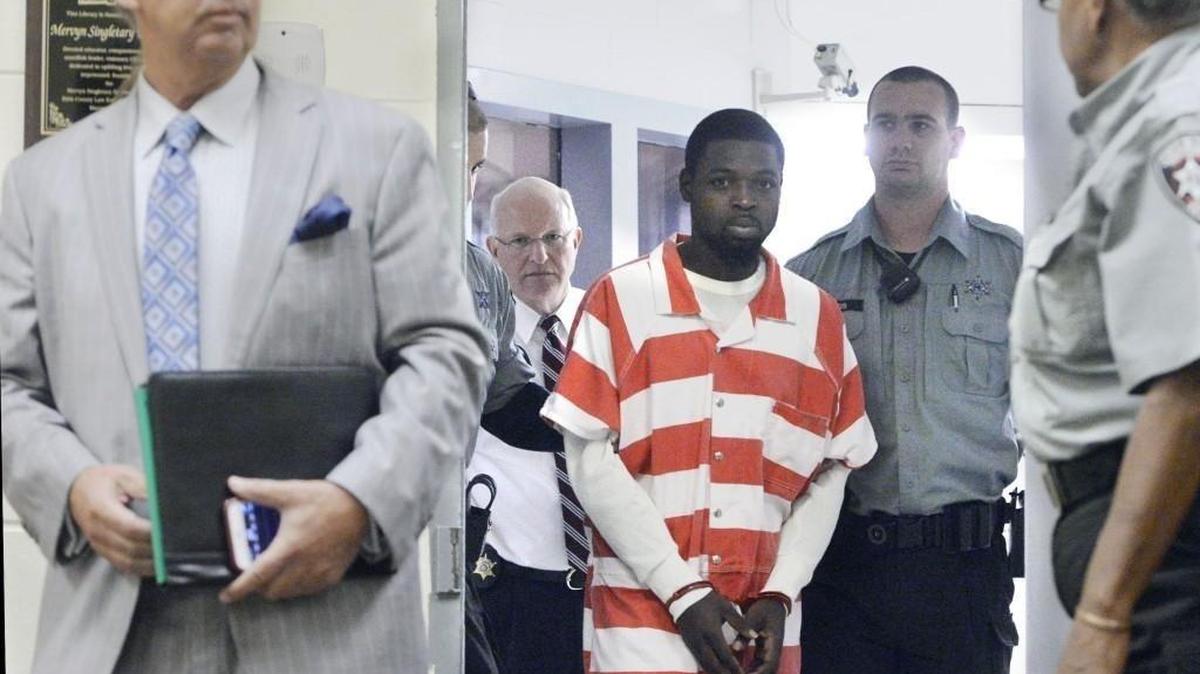 Martavius Kinder (center) makes his way before a Bibb County magistrate for a May hearing with his attorney Franklin J. Hogue, left, and Sheriff David Davis.