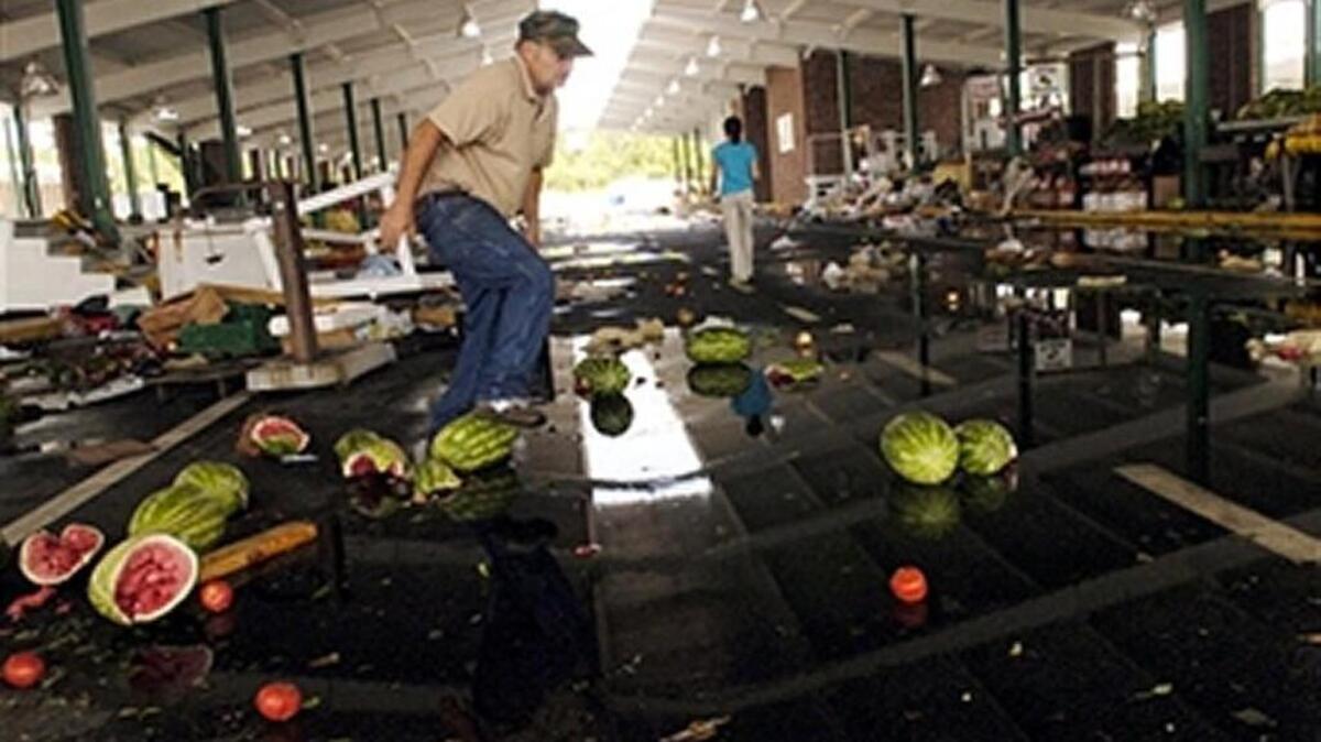 Royce Brannen, of Unadilla, steps over a busted watermelon while cleaning up his produce stand at the State Farmers' Market in Macon, Georgia, after a tornado passed through the area early Sunday, May 11, 2008, in this Telegraph file photo. A crash on a ramp of Interstate 85 created a similar watermelon mess for rush-traffic early Thursday, Atlanta area media outlets reported.