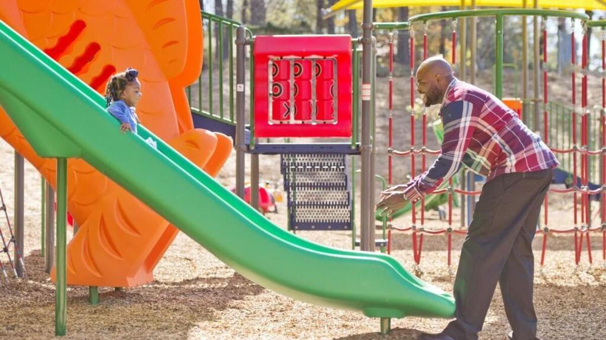 Broderick Jackson waits on his niece Lydia Wright, 2, at the bottom of the slide after a ribbon cutting ceremony at Filmore Thomas Park Monday. Jackson is the grandson and Wright is the great granddaughter of Thomas.