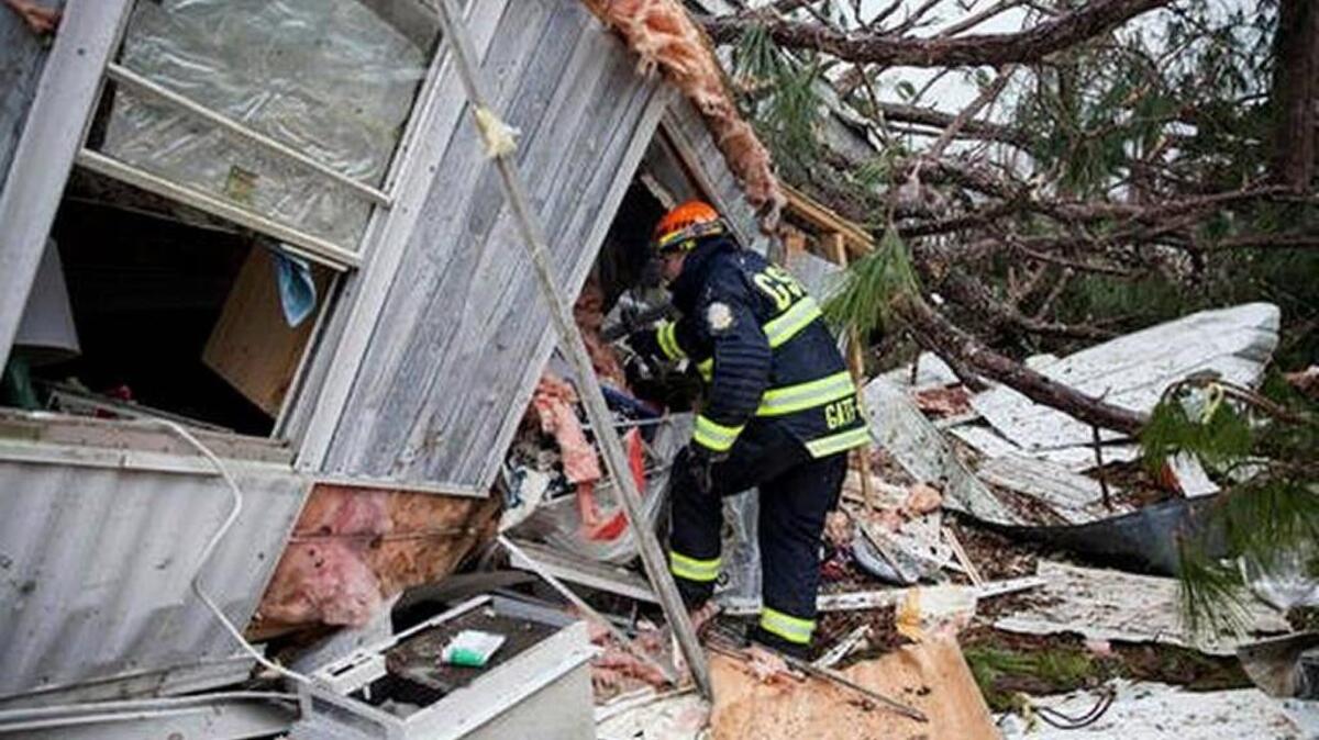 A rescue worker enters a hole in the back of a mobile home Monday, in Big Pine Estates that was damaged by a tornado, in Albany, Ga. Fire and rescue crews were searching through the debris, looking for people who might have become trapped when the deadly storm came through.