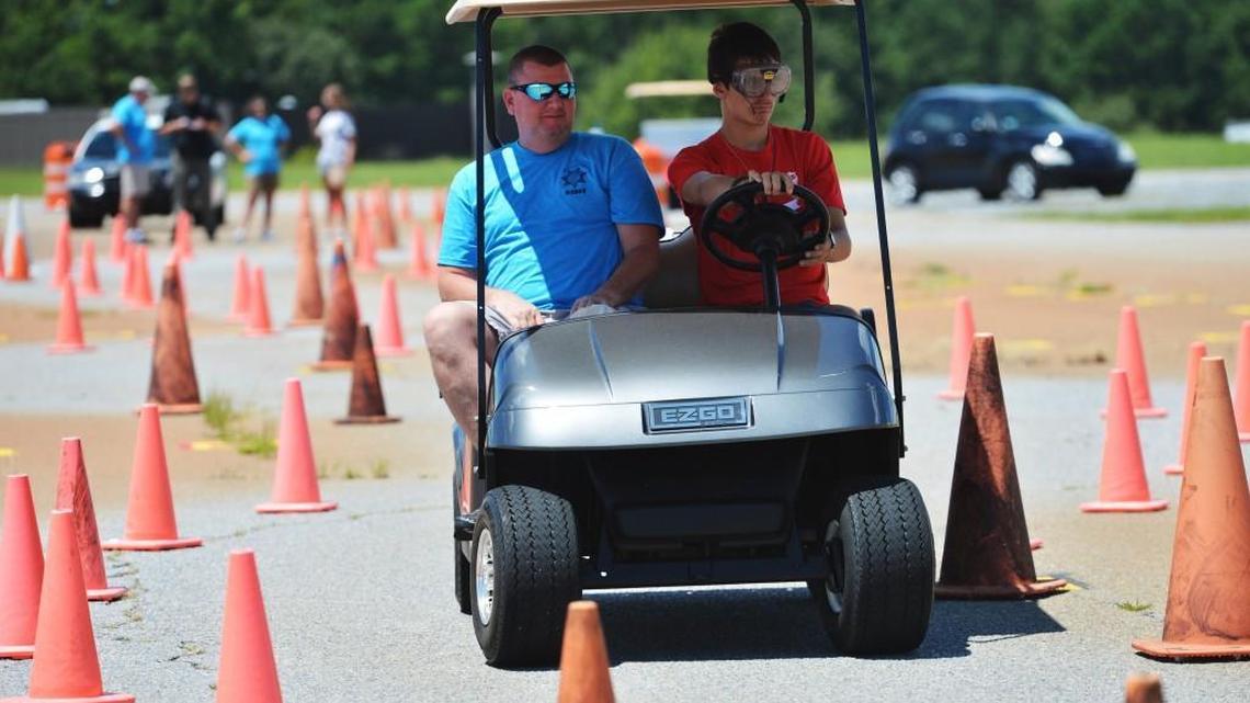In August 2013, Ernie Strickland drives a golf cart through a course using a pair of goggles that provide a similar impairment of vision that a person who had had a few drinks might have if they got behind the wheel to soon. Monroe County deputy Troy Copelan, left, supervised the exercise that dramatized how difficult it could be to steer a car between the white lines.